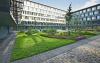 Courtyard with walking areas, lawn and plant beds with shrubs and small trees